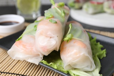 Photo of Delicious spring rolls wrapped in rice paper on table, closeup