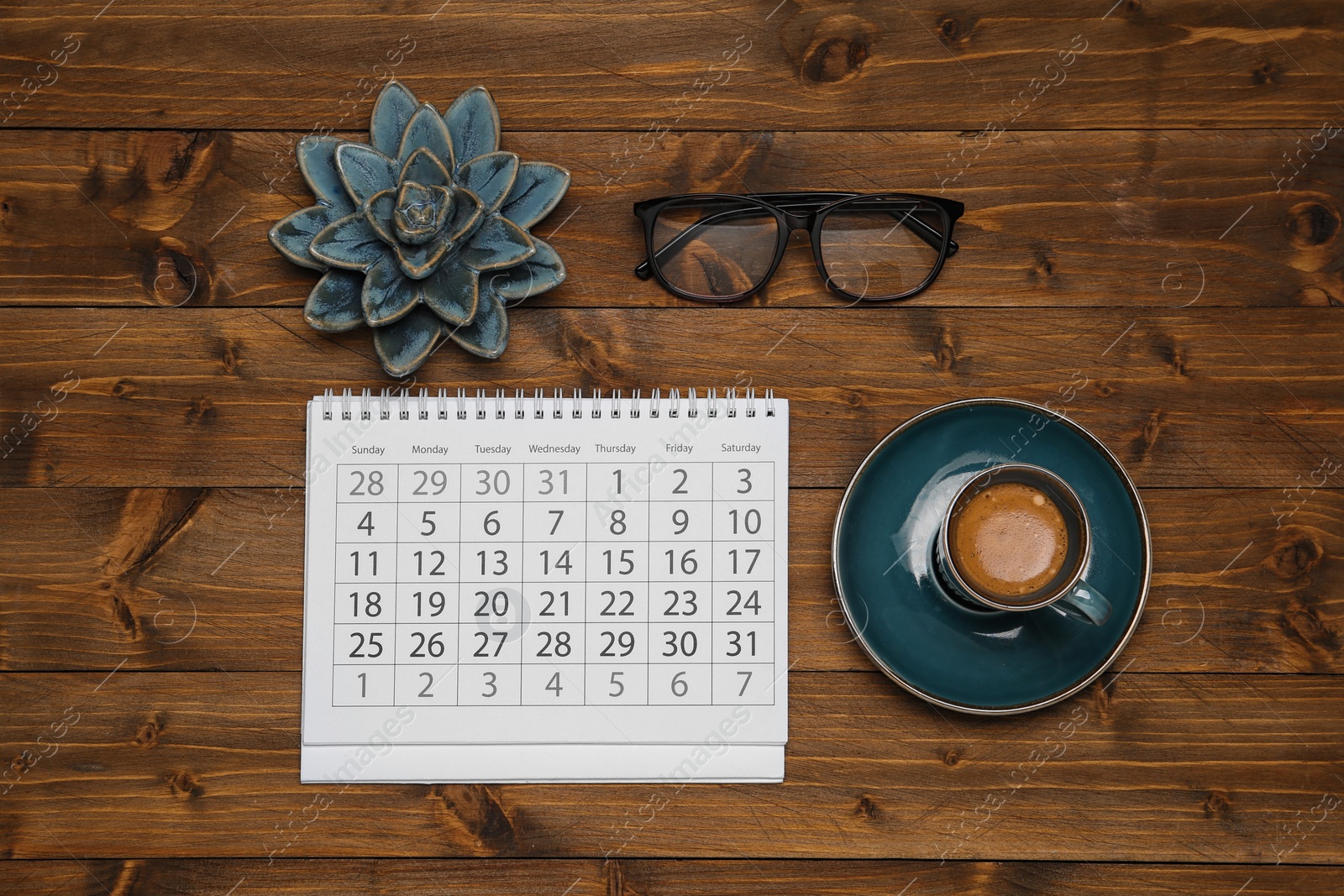 Photo of Flat lay composition with calendar and cup of coffee on wooden table