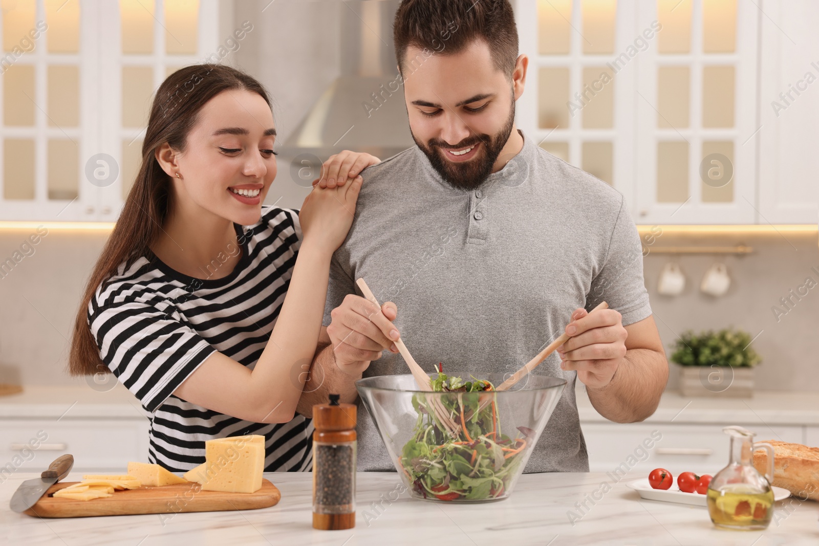 Photo of Lovely young couple cooking together in kitchen