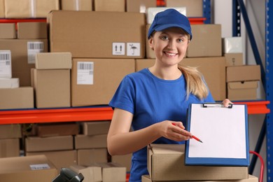 Post office worker with clipboard and parcels near rack indoors, space for text