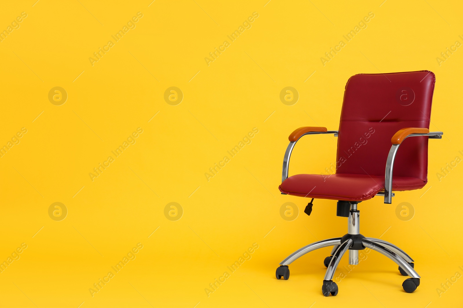 Photo of Modern office chair on yellow background. Space for text