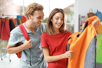 Photo of Young couple choosing sleeping bag in store