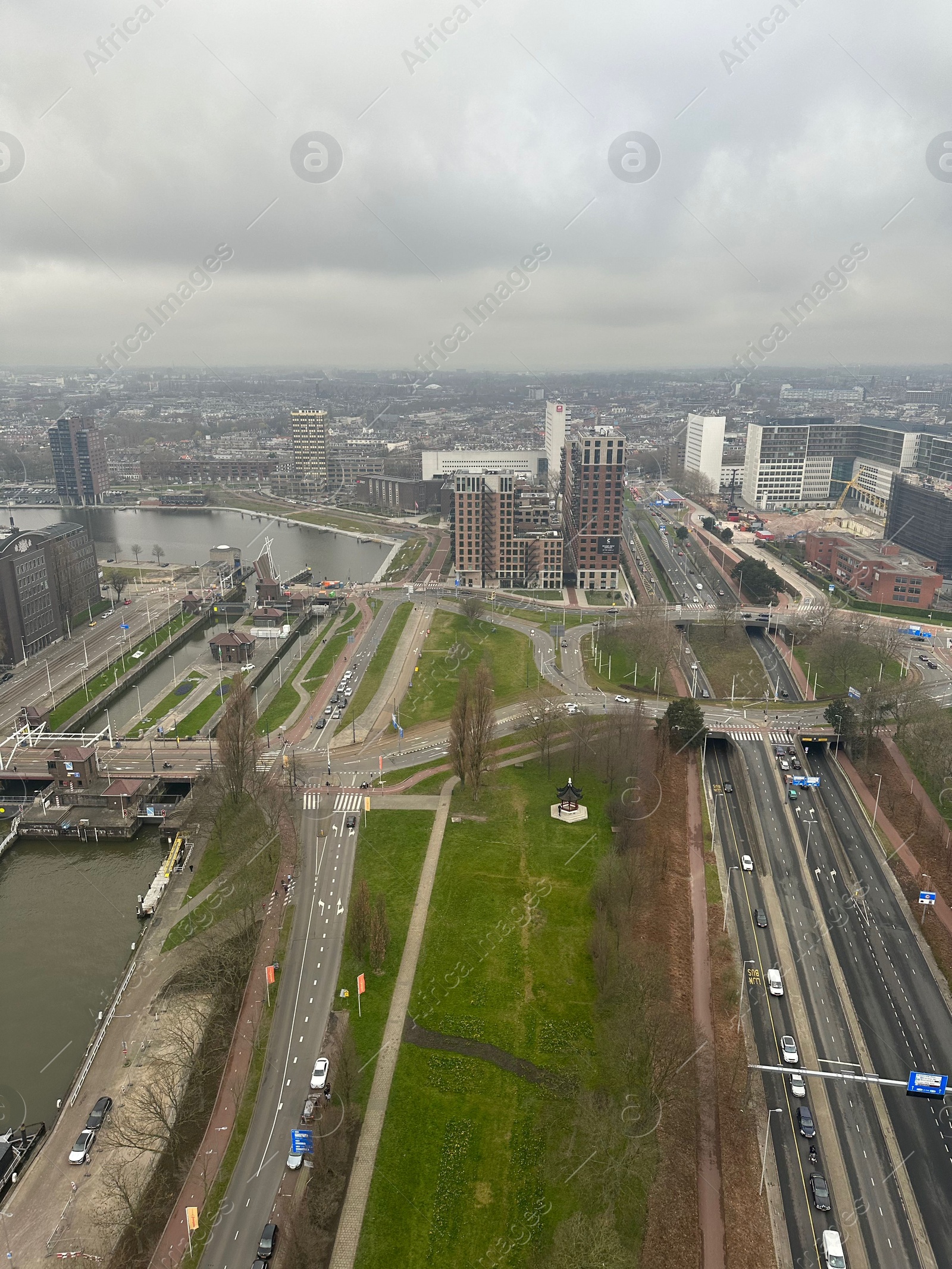 Photo of Picturesque view of city with modern buildings and highway on cloudy day