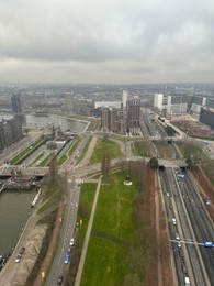 Photo of Picturesque view of city with modern buildings and highway on cloudy day