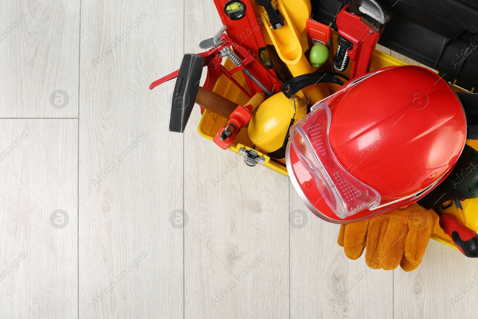 Photo of Box with professional tools for repair on white wooden table, top view. Space for text