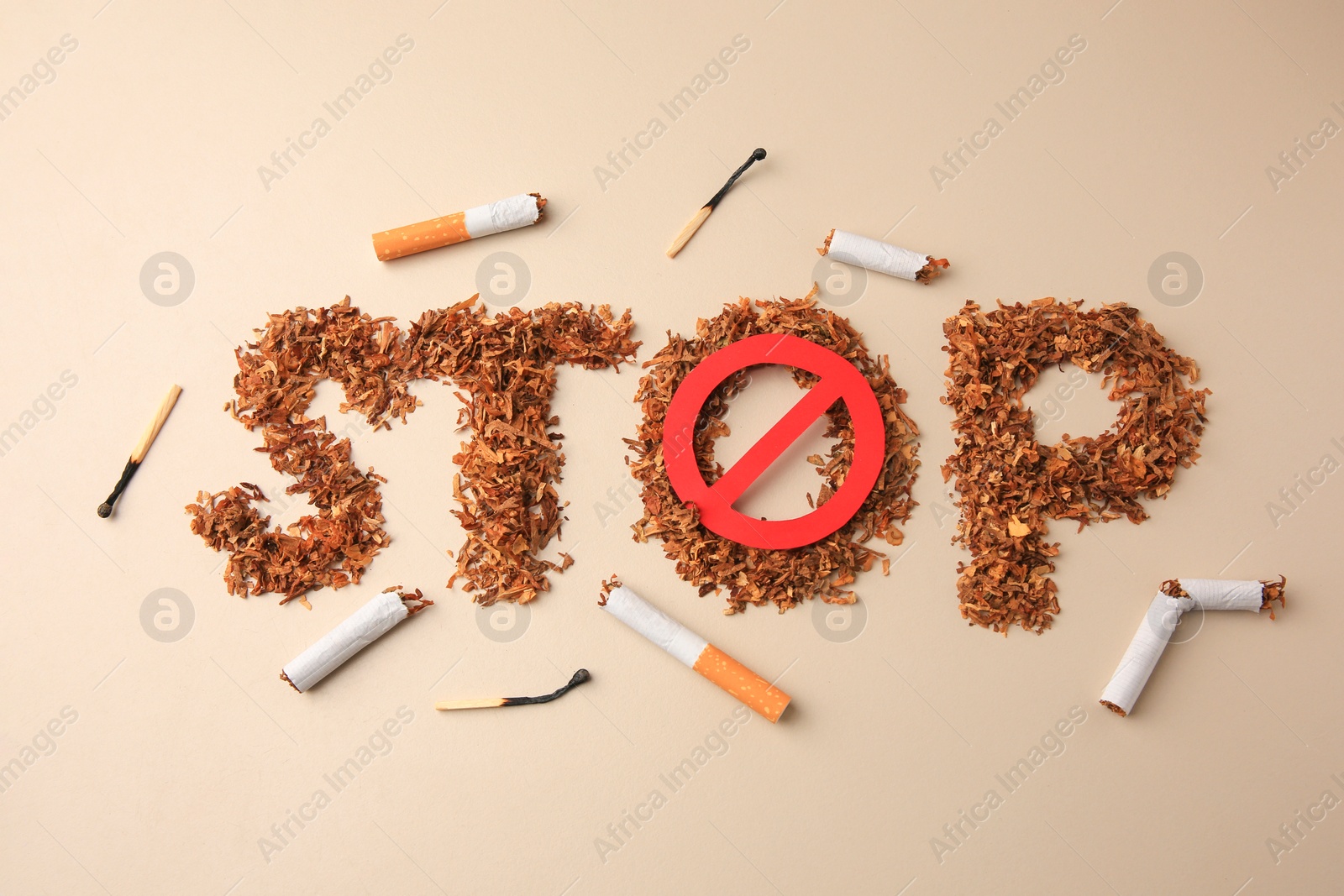 Photo of Flat lay composition with word Stop made of dry tobacco and prohibition sign on beige background. Quitting smoking concept