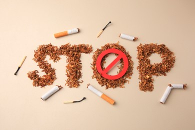 Photo of Flat lay composition with word Stop made of dry tobacco and prohibition sign on beige background. Quitting smoking concept