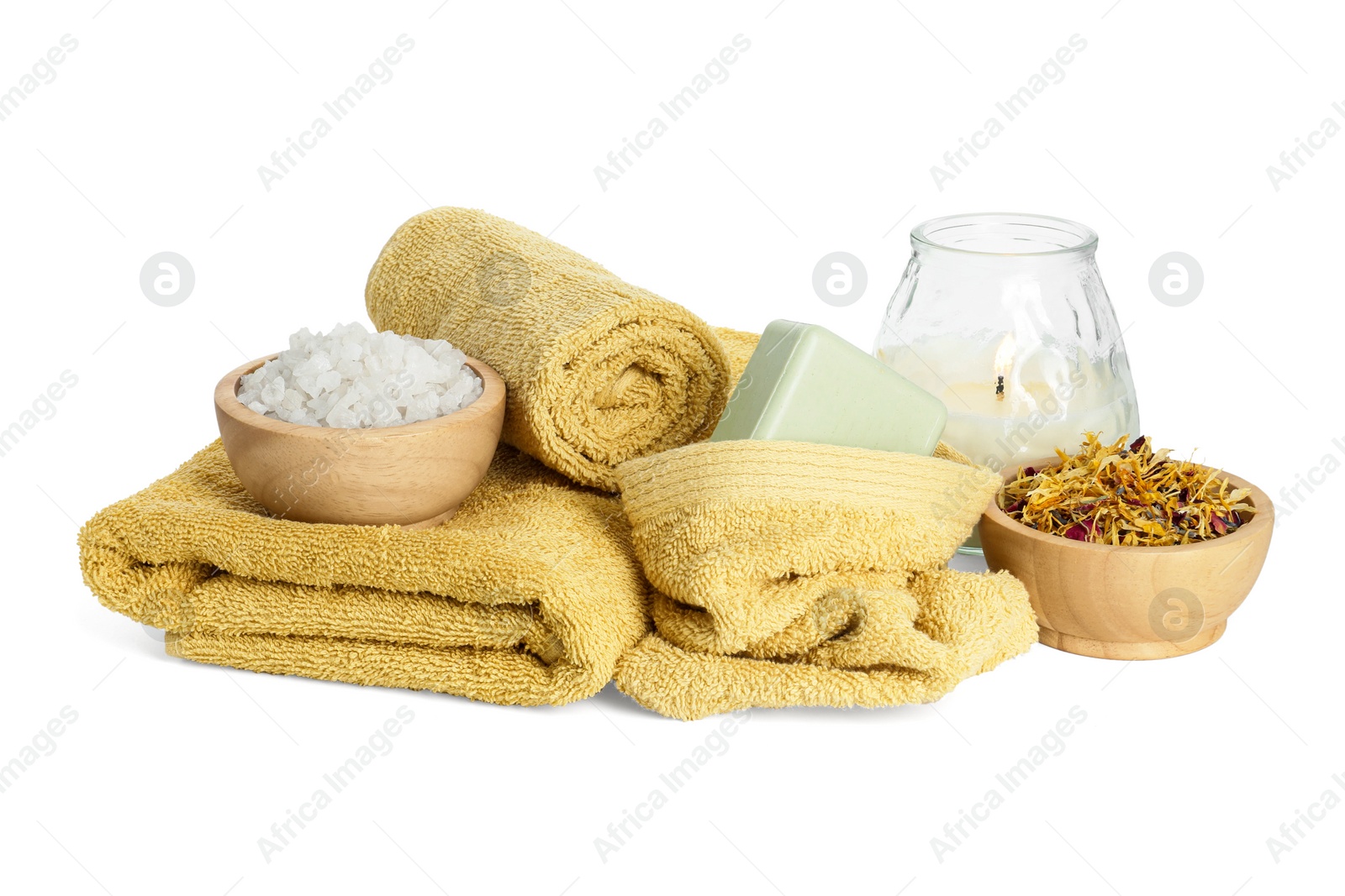 Photo of Spa composition. Towels, burning candle, sea salt, soap and dry flowers on white background