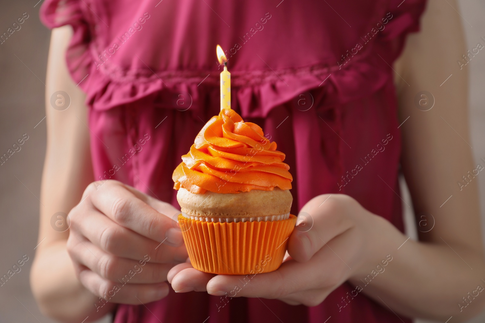 Photo of Woman holding birthday cupcake, closeup