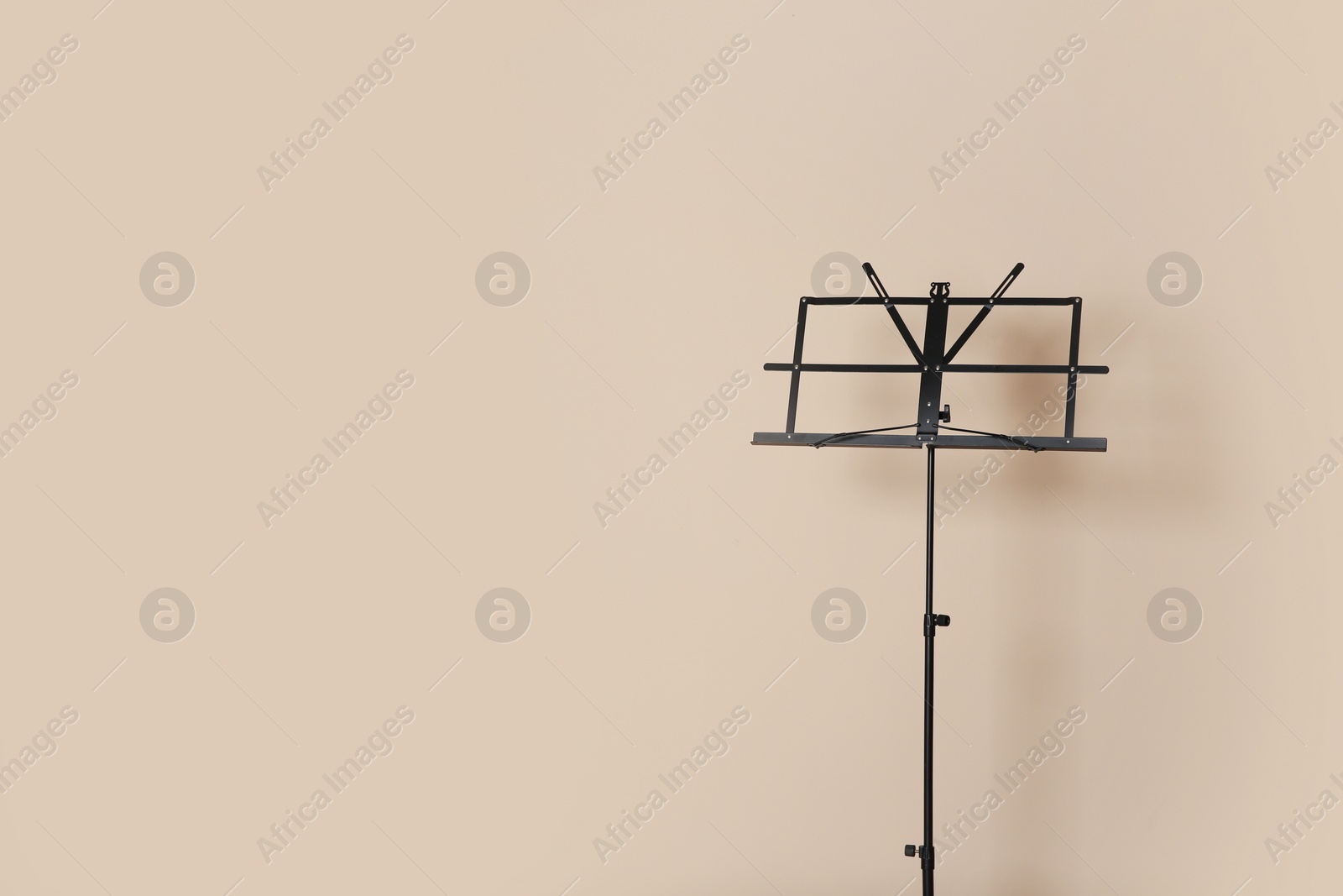 Photo of Empty music note stand on color background. Space for text