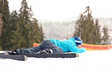 Photo of Clumsy skier on slope at resort. Winter vacation