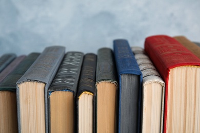 Photo of Stack of hardcover books on light blue background, closeup