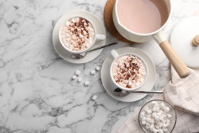 Photo of Aromatic hot chocolate with marshmallows and cocoa powder served on white marble table, flat lay. Space for text