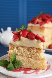 Photo of Piece of tasty cake with fresh strawberries and mint on table, closeup