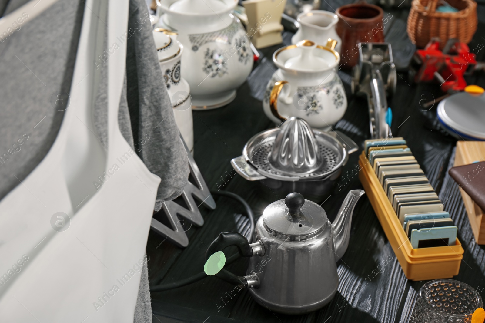 Photo of Many different stuff on black wooden table. Garage sale