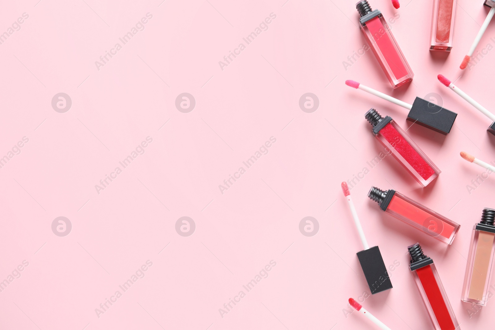 Photo of Beautiful flat lay composition of liquid lipsticks and space for text on color background