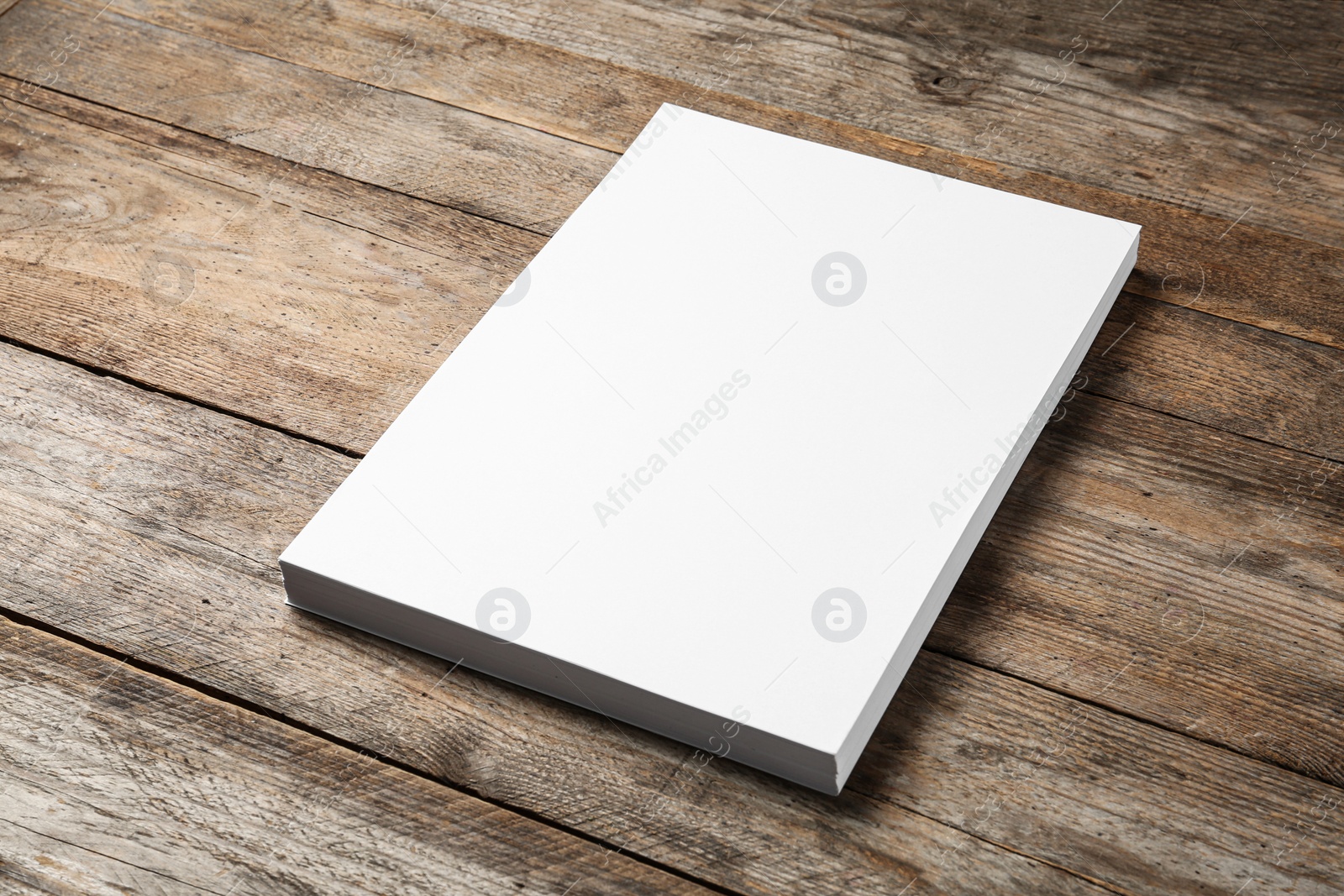 Photo of Stack of blank paper sheets for brochure on wooden background. Mock up