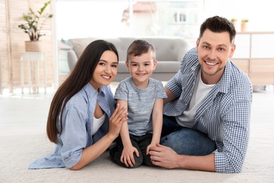 Happy couple with their son spending time together at home. Family weekend