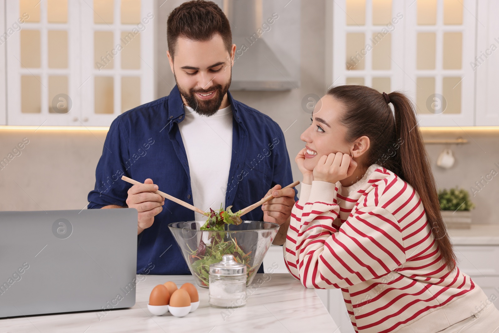 Photo of Happy lovely couple cooking together in kitchen