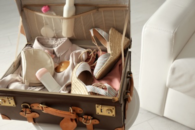 Photo of Vintage suitcase with deodorants and clothes at home