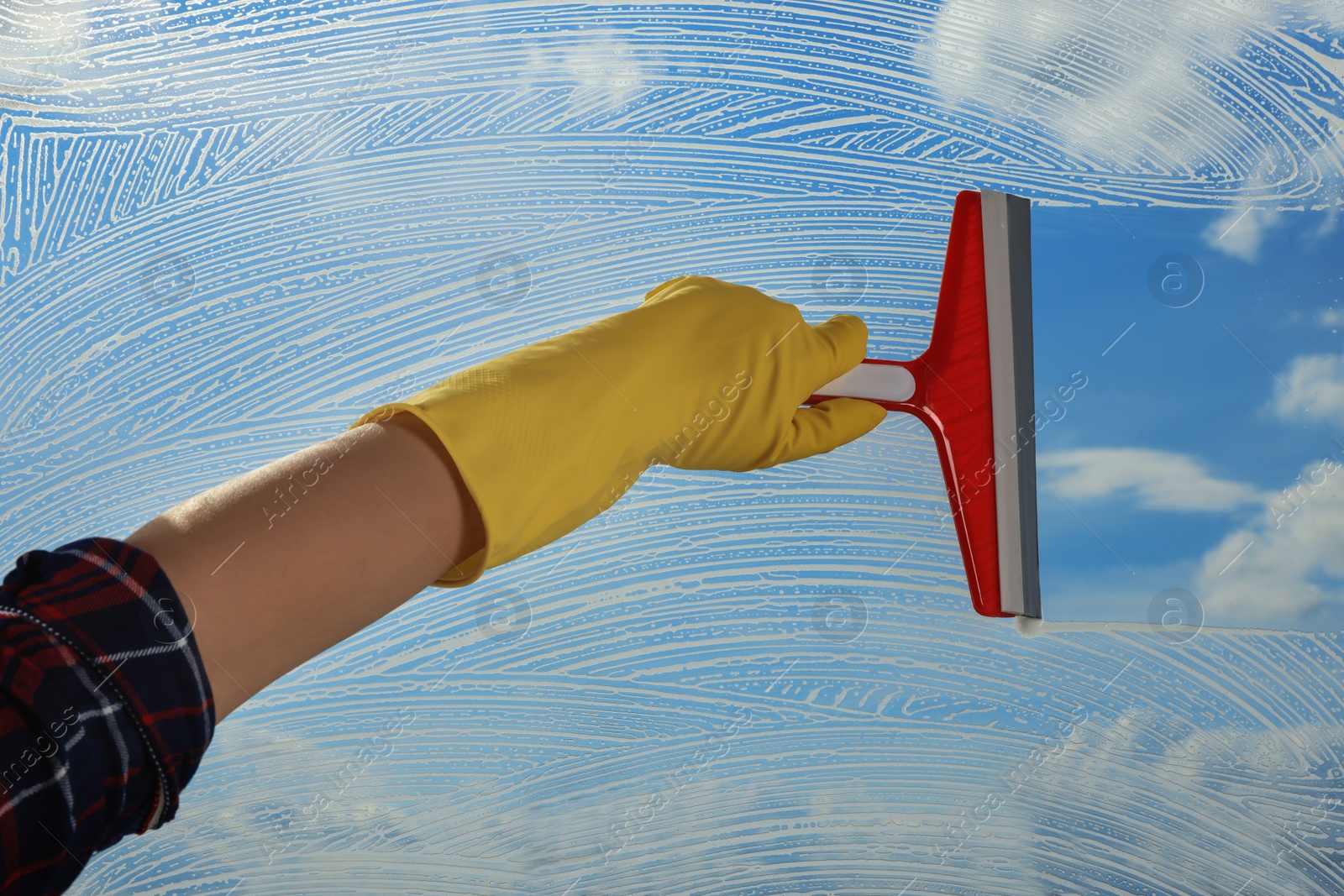 Photo of Woman cleaning glass with squeegee indoors, closeup