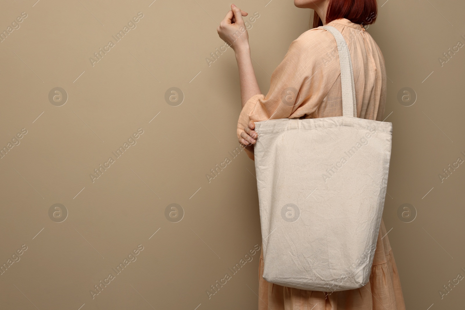 Photo of Woman with eco bag on beige background, closeup. Space for text