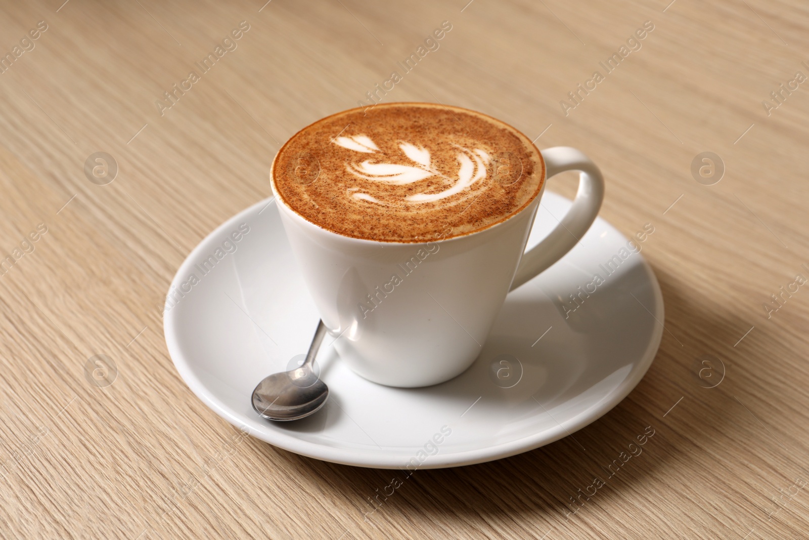 Photo of Cup of aromatic coffee and spoon on wooden table