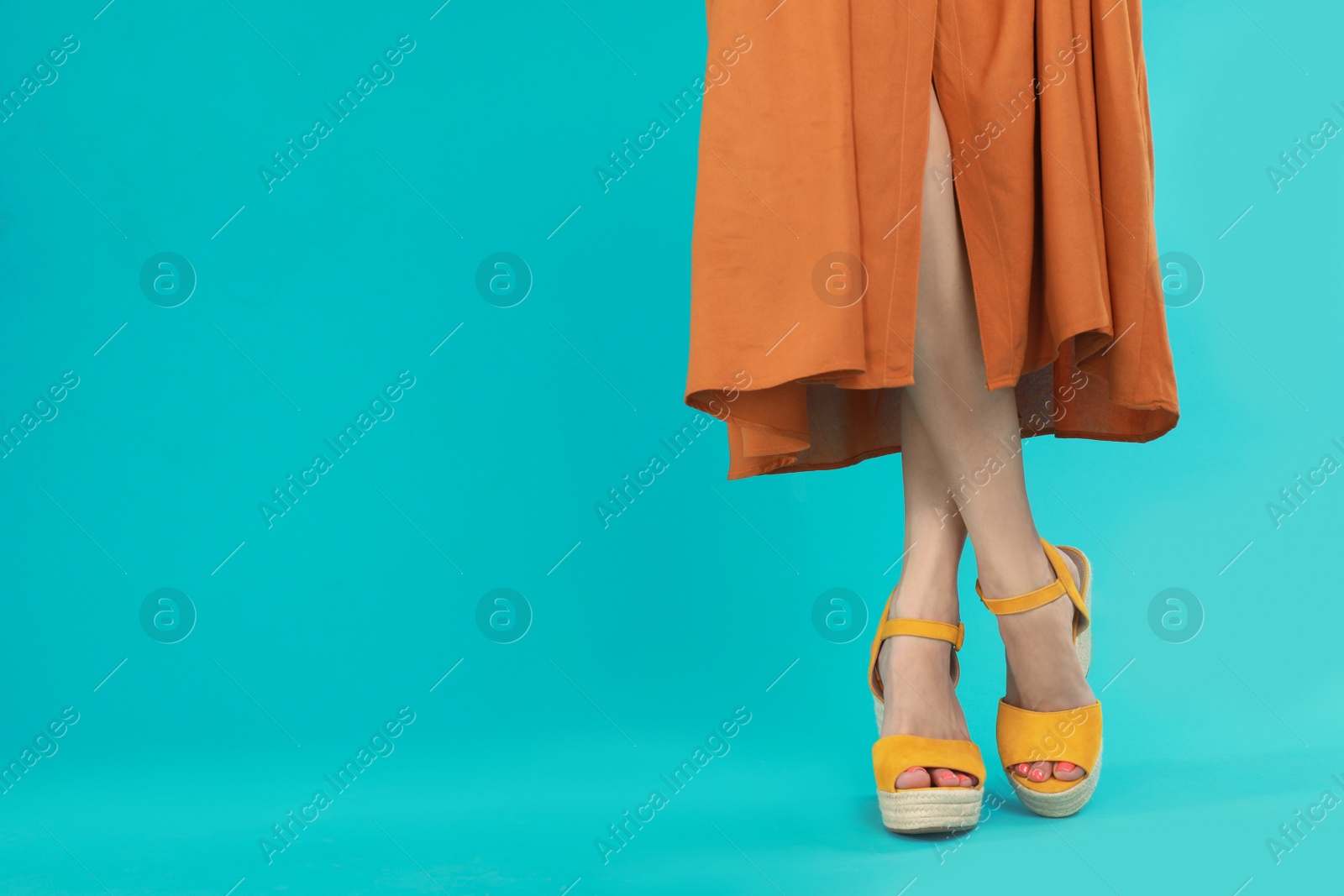 Photo of Woman in stylish shoes on light blue background. Space for text