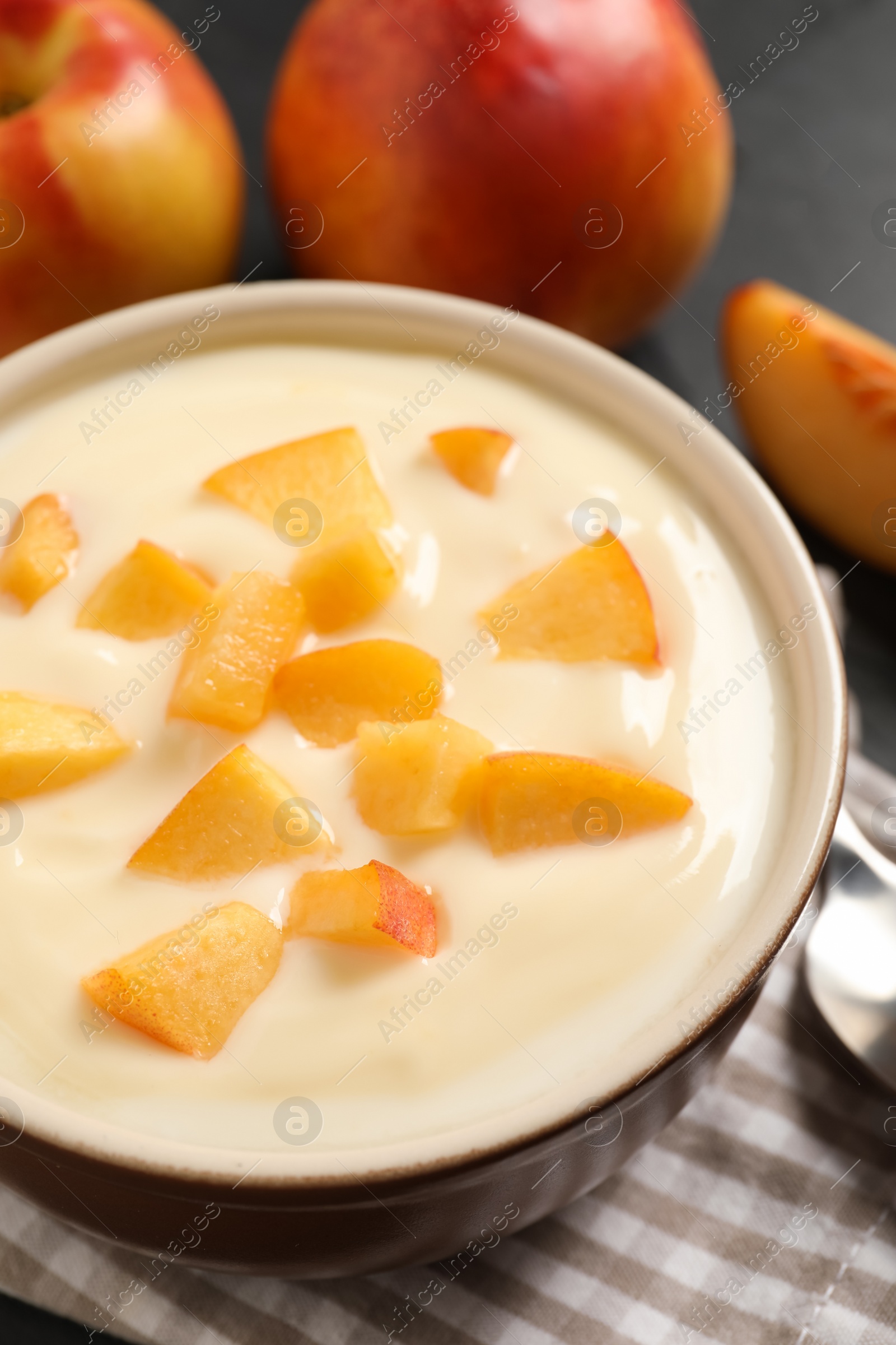 Photo of Delicious yogurt with fresh peach on table, closeup