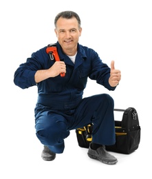 Mature plumber with pipe wrench and tool bag on white background