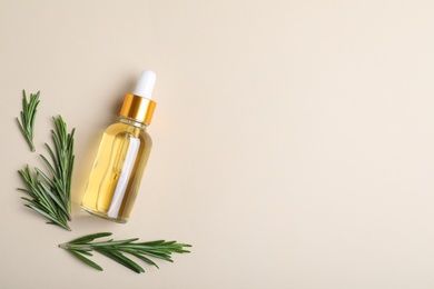 Flat lay composition with rosemary essential oil and space for text on beige background