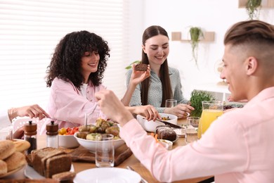 Photo of Friends eating vegetarian food at table indoors