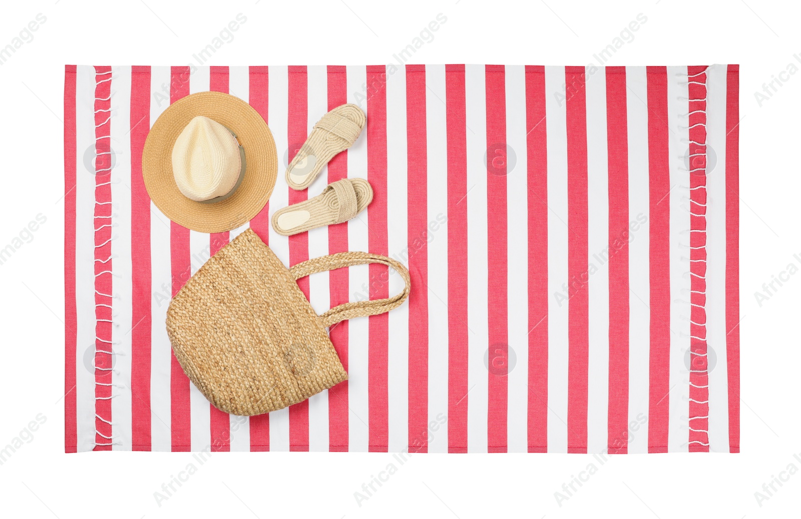 Photo of Striped beach towel with slippers, straw hat and bag on white background, top view
