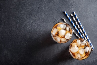 Photo of Glasses of refreshing cola with ice cubes on grey background, top view. Space for text