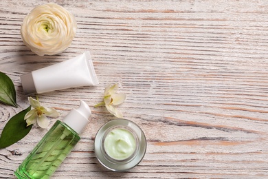 Flat lay composition with cosmetic products on wooden background