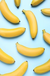 Photo of Sweet ripe baby bananas on turquoise background, flat lay