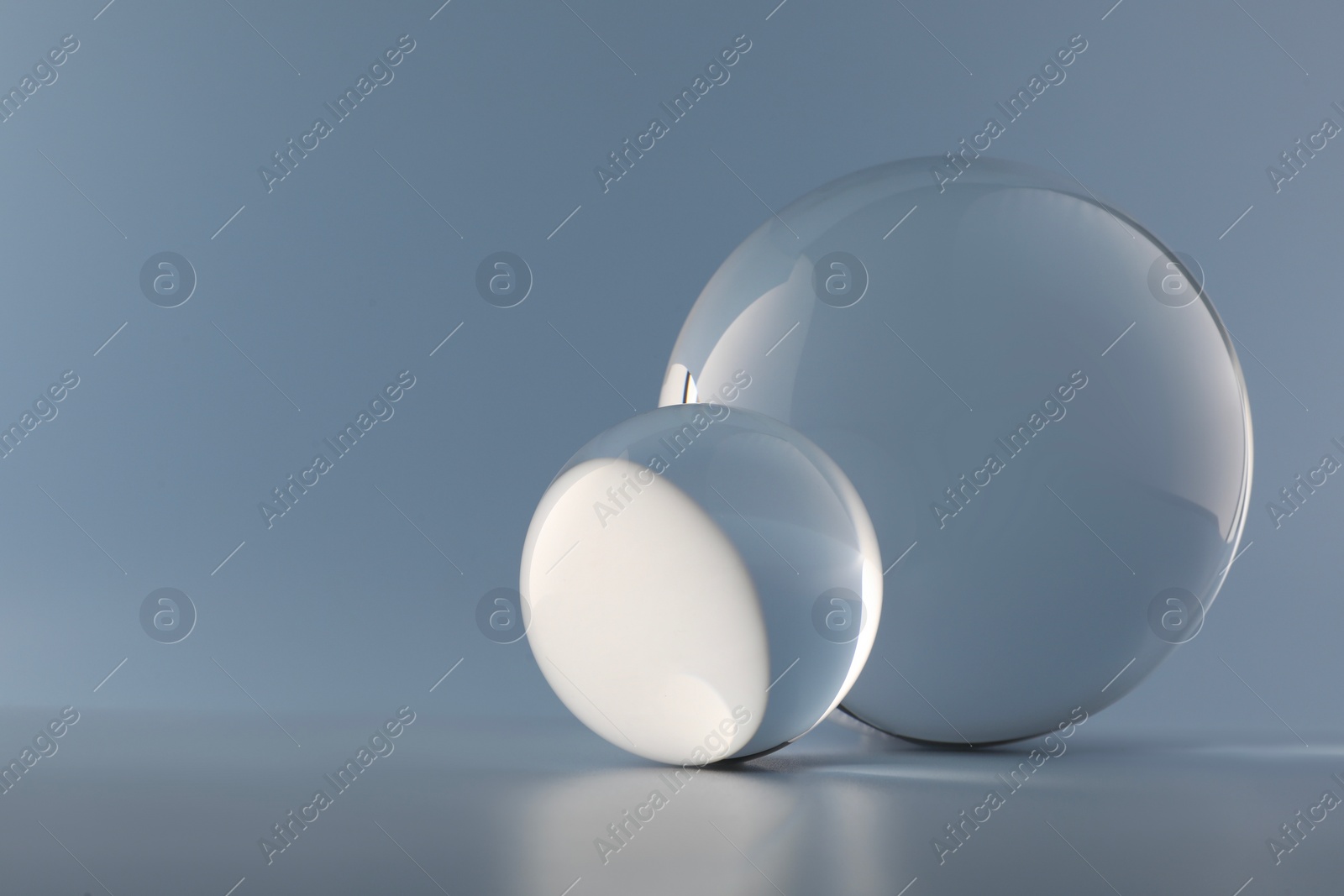 Photo of Transparent glass balls on light grey background. Space for text
