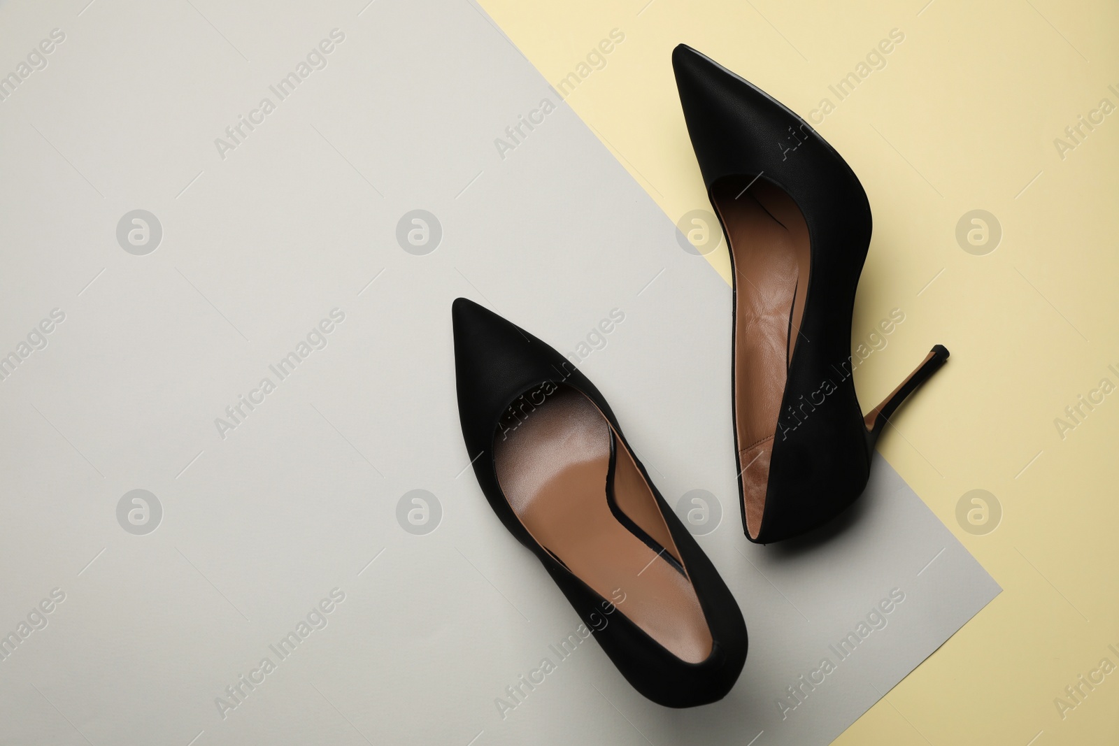 Photo of Pair of elegant black high heel shoes on color background, flat lay. Space for text