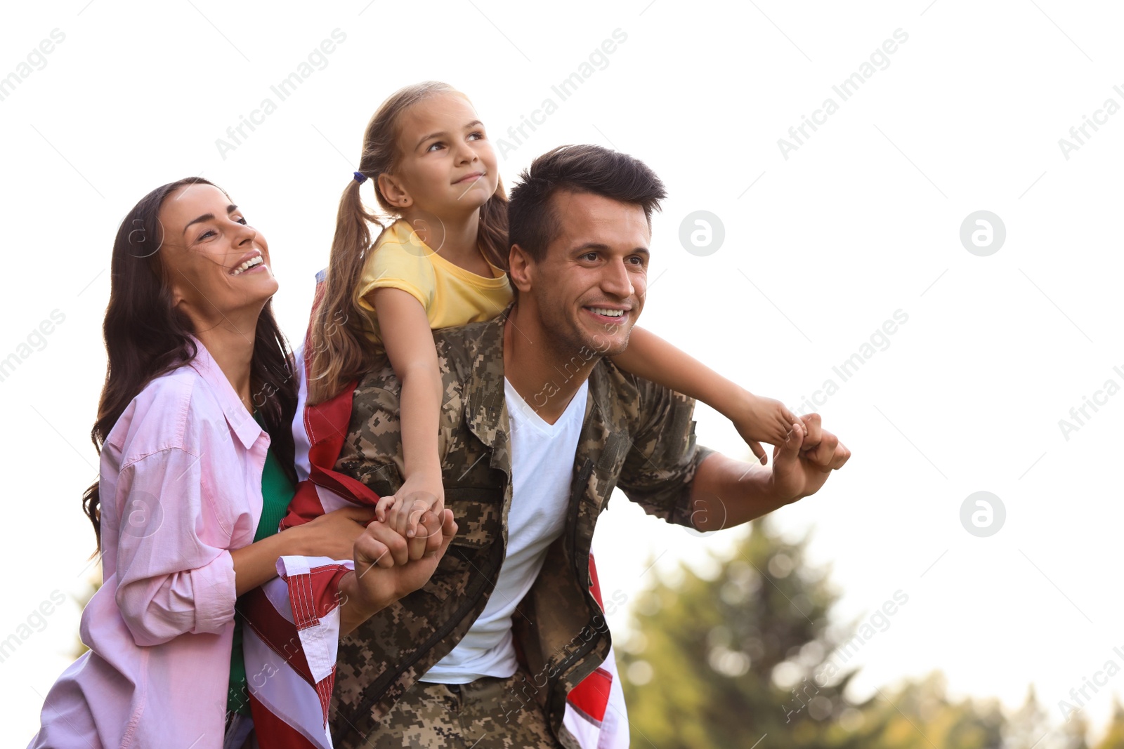 Photo of Man in military uniform and his family at sunny park