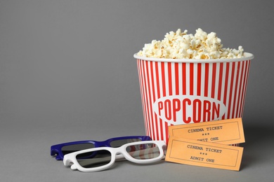 Photo of Popcorn, cinema tickets and 3d glasses on grey background. Space for text