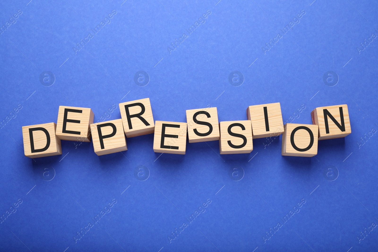 Photo of Word Depression made of wooden cubes on blue background, flat lay