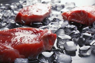 Raw meat and ice cubes on table