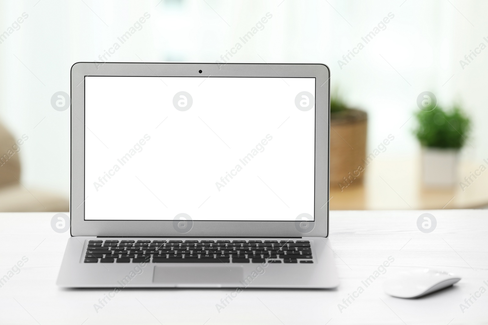 Photo of Laptop with blank screen on table indoors. Space for text