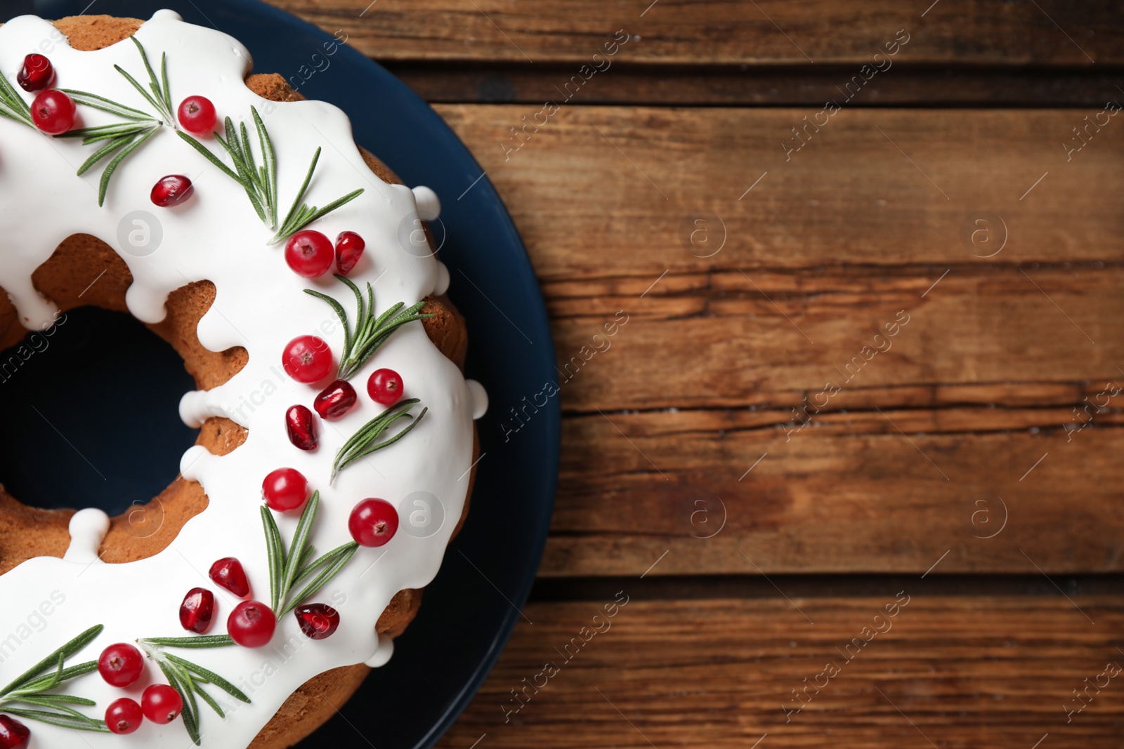 Photo of Traditional homemade Christmas cake on wooden table, top view. Space for text