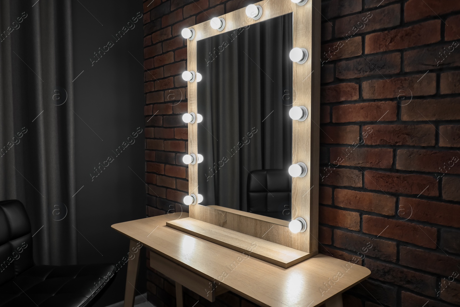 Photo of Mirror with light bulbs and table in makeup room