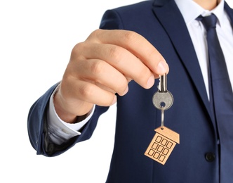 Photo of Real estate agent holding key on white background, closeup