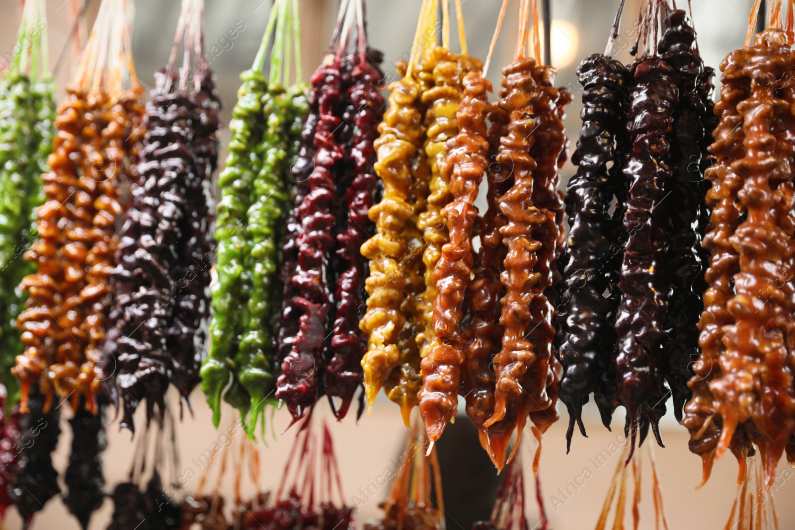 Photo of Bunches of different delicious churchkhelas at market