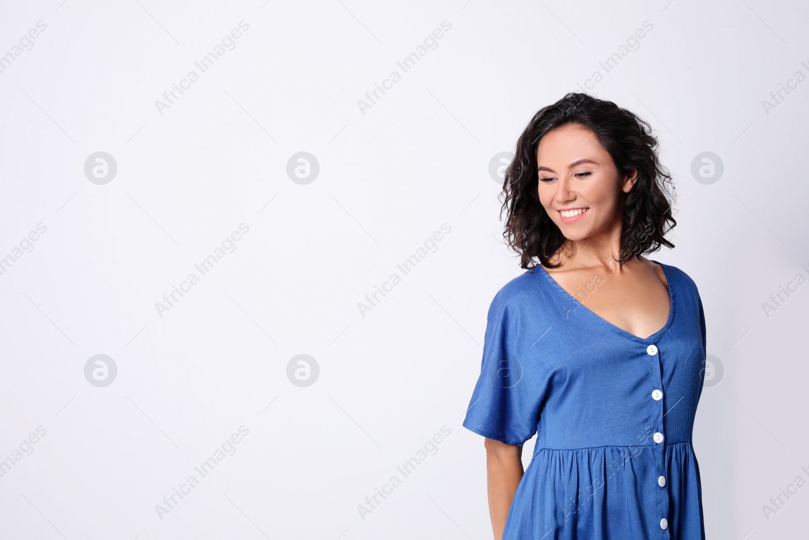 Photo of Happy young woman in casual outfit on light background. Space for text