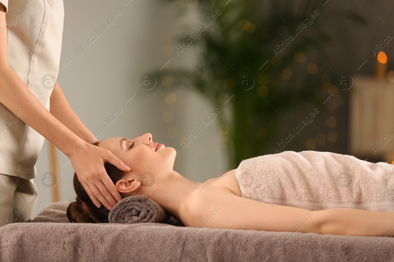 Photo of Beautiful young woman enjoying massage in spa salon