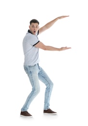 Emotional man in casual clothes holding something on white background